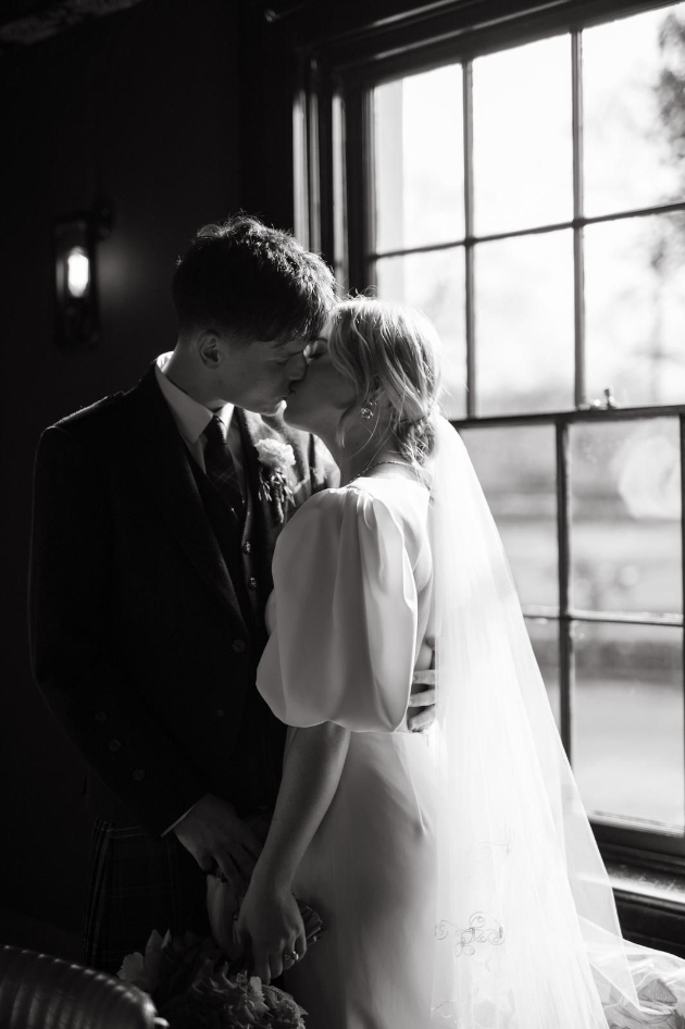 black and white image of bride and groom kissing at The Vicarage Cranage