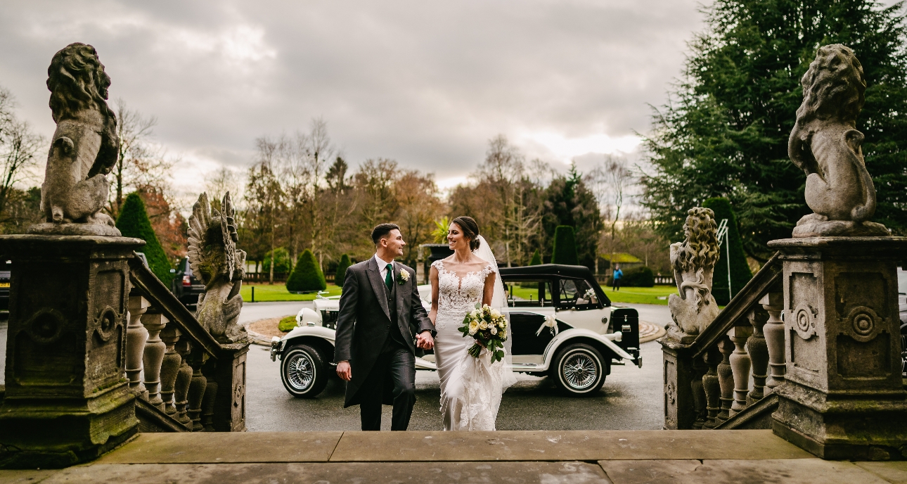 Bride and groom walking up steps together at Crewe Hall