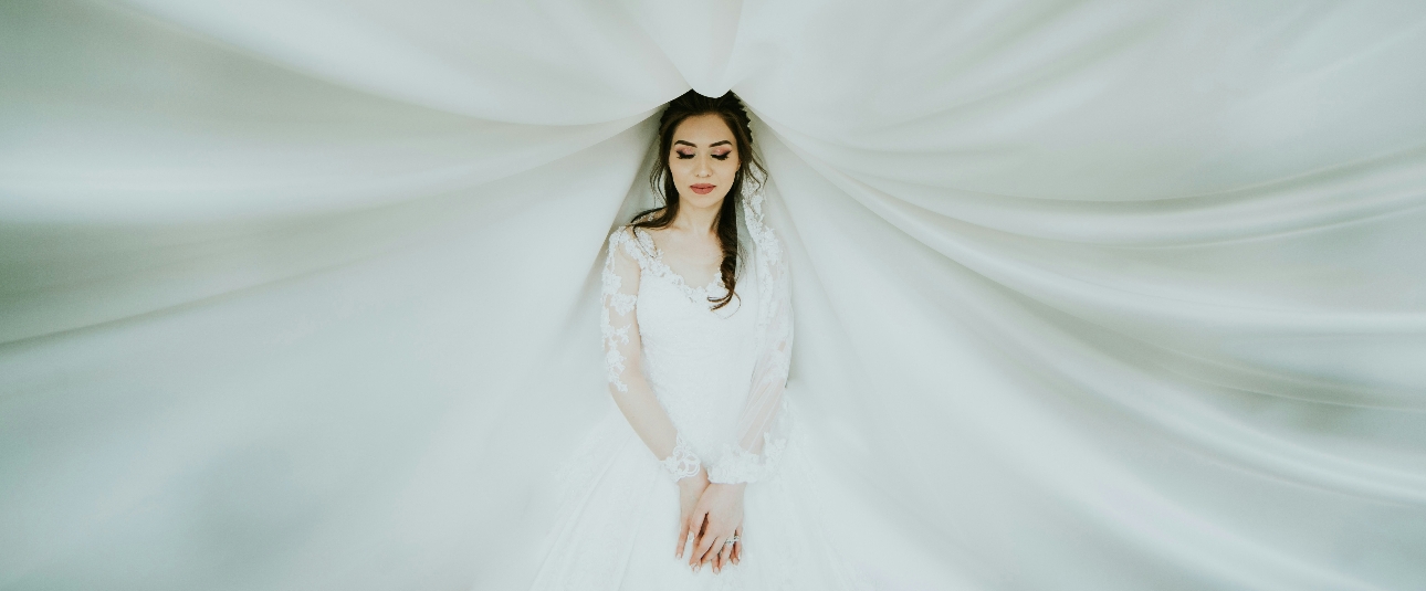 Dreamy bride surrounded by white fabric