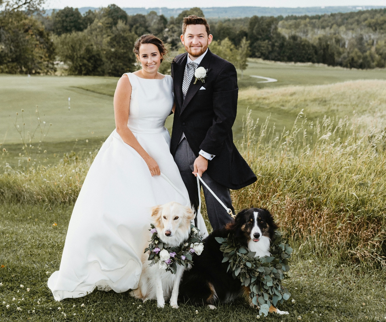 bride and groom on wedding day with two dogs