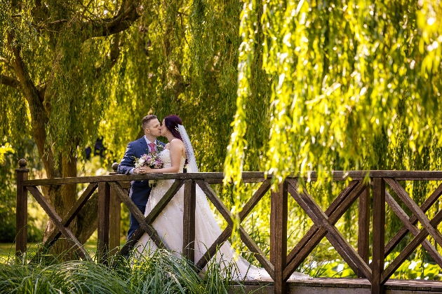 Bride and groom on bridge in grounds of Grosvenor Pulford Hotel