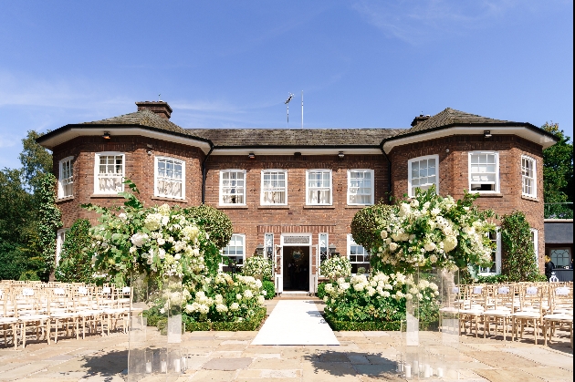 Exterior of Delamere Manor with wedding aisle leading up to it decorated with white flowers