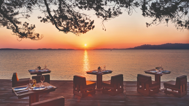 tables and chairs on deck at sunset